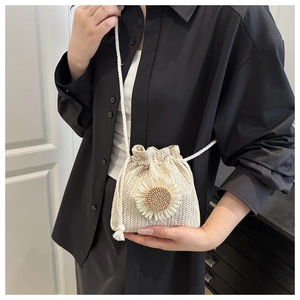 Detail of cream woven bucket bag featuring large floral ornament on a black shirt backdrop