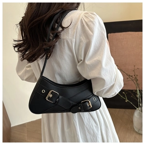 Detail of a black crescent underarm bag with metal eyelets and y2k moto style straps