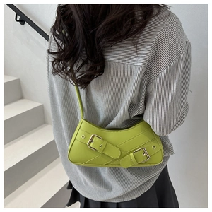 Detail of a bright green Y2K baguette bag featuring double metal buckle straps on faux leather