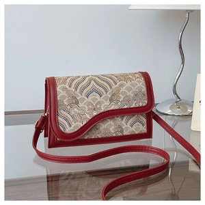 Detail of vintage Chinese style crossbody bag with jacquard cloud pattern and red leather