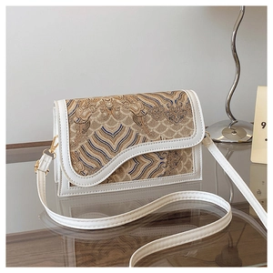 Close-up of traditional jacquard fabric with cloud patterns and wavy flap on shoulder bag