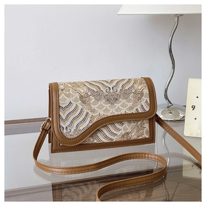 Detail of vintage Chinese style crossbody bag featuring jacquard fabric and brown leather