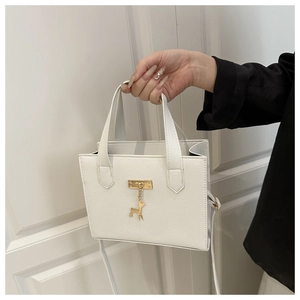 Détail du sac à main blanc en cuir grainé avec pendentif cerf doré et fermoir en métal