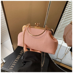 Detailed view of pink woven clutch bag with gold vintage metal clasp and chain handle