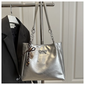 Close-up of silver metallic tote bag with crinkled texture and bow detail