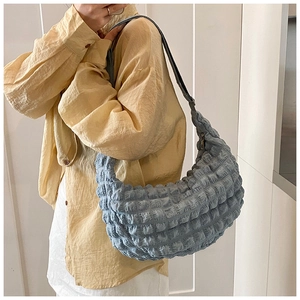Detail view of light blue bubble textured shoulder bag with soft pleated crescent design
