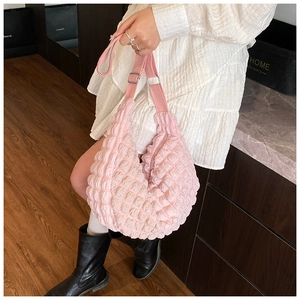 Detail of pink crinkle textured crossbody bag with adjustable strap and silver buckle