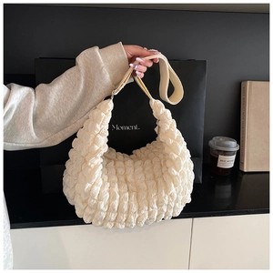 Detailed close-up of cream-white cloud bag showing textured bubble pleated fabric and soft handle