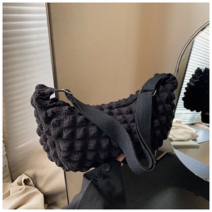 Close-up of black waffle fabric moon bag with soft puffy texture and wide shoulder strap