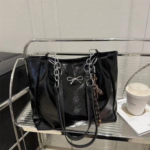 Glänzende schwarze Lackleder-Einkaufstasche mit silberner Schleife und Kettenriemen