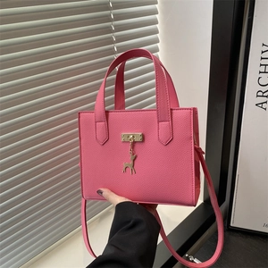 Sac à main rose texture litchi avec pendentif cerf doré et bandoulière ajustable