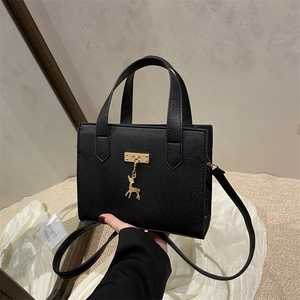 Sac à main carré noir chic avec motif litchi, détails dorés et pendentif cerf élégant