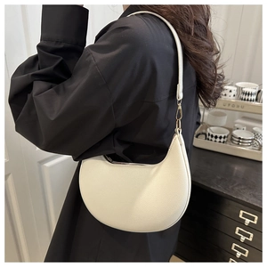 Model wearing a minimalist cream crescent underarm bag with lychee texture and gold buckle