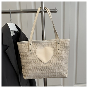 Détail du tissage en V et du patch coeur en cuir sur le sac fourre-tout de plage