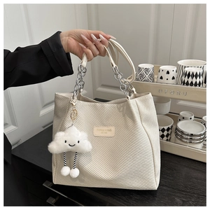 Détail du sac cabas en velours côtelé crème avec chaîne argentée et breloque nuage