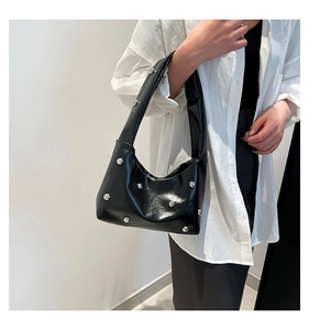Black crescent shoulder bag with silver rivets shown on model for size perspective
