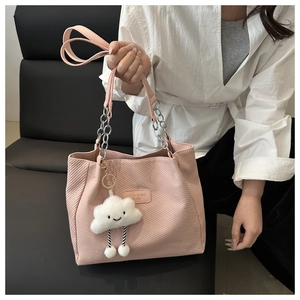 Détail du sac cabas rose en velours côtelé avec bandoulière chaîne et charme nuage