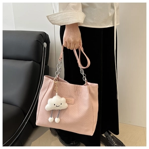 Détail du cabas en velours côtelé rose avec poignée en chaîne et pendentif nuage doux