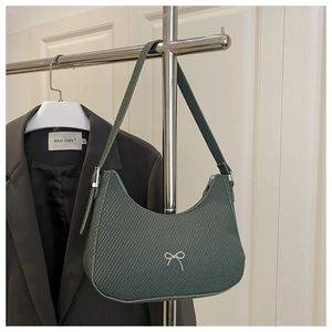 Detail of dark green woven hobo bag with a delicate silver metallic bow accent