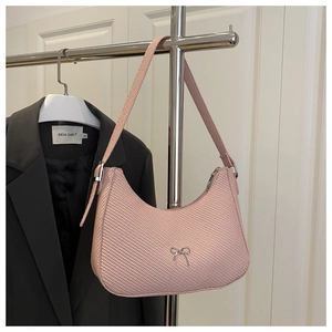 Detail of pink woven hobo bag with silver bow ornament and leather strap on hanger