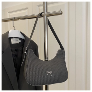 Detail view of dark grey hobo bag with grid texture and silver bow metal buckle