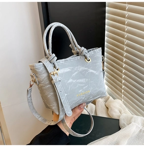 Detail of grey marble textured handbag with gold Fashion text and double round handles