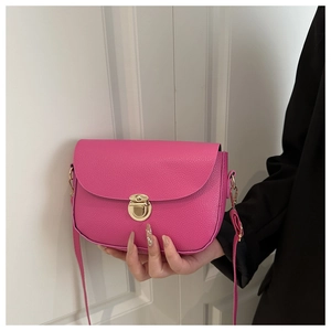 Close-up of bright pink lychee grain faux leather handbag with golden cylinder push lock