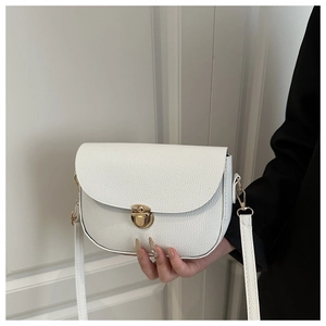 Close-up of white lychee texture leather bag with a vintage gold metal lock and U-shaped base