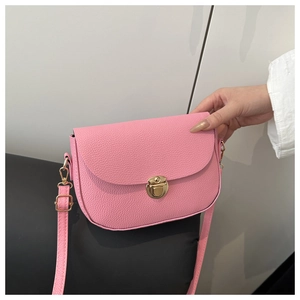 Close-up of pink lychee pattern texture and gold metal lock on a shoulder bag
