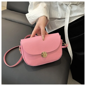 Detailed macro shot of pink litchi grain leather bag with a gold twist lock closure
