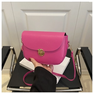Detail of rose pink lychee grain leather crossbody bag with golden metallic clasp