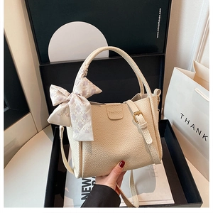 Chic cream white bucket bag with pebble leather texture and silk scarf detail