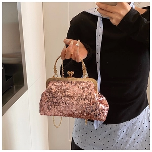 Close-up of pink sequined evening bag with vintage gold metal handle and chain