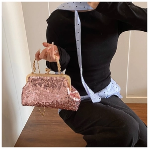Close-up of rose gold sequin evening bag with vintage engraved metal handle and chain strap