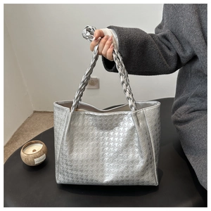 Détail du sac cabas argenté avec motif pied-de-poule et anse en cuir tressé
