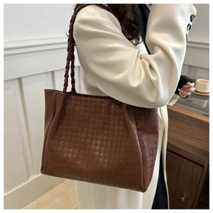 Détail du sac cabas marron vintage avec motif pied-de-poule et bandoulière tressée