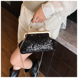 Detail of elegant black sequin evening bag with gold handle and metal chain strap