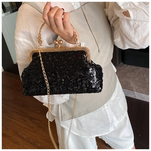 Close-up of black sequined evening clutch with gold metal handle and chain strap