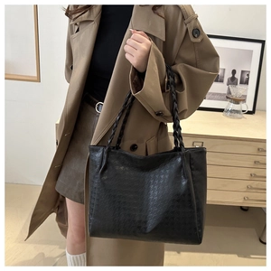 Gros plan sur un sac cabas noir à texture tissée et bandoulières en corde assorties