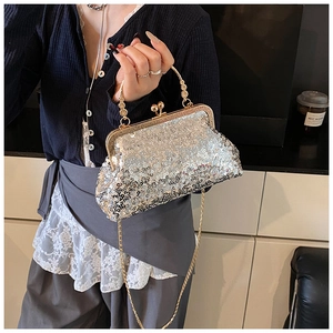 Close-up of silver sequin evening bag with gold metal frame and spherical clasp detail