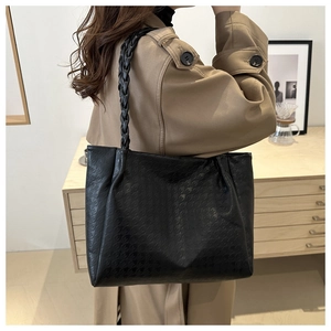 Détail du sac cabas noir avec texture pied-de-poule et bandoulière tressée chic