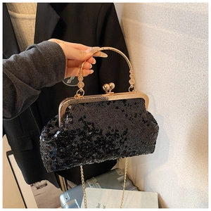 Close-up of black sequin evening bag with gold circular handle and fine chain strap