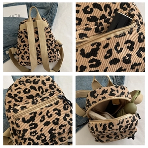 Detail of leopard print corduroy backpack featuring multiple zip pockets and adjustable straps