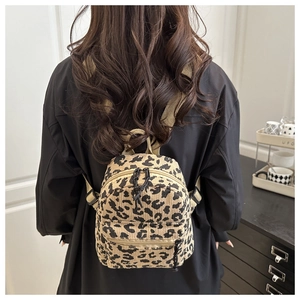 Mini leopard print corduroy backpack with brown straps shown on a model