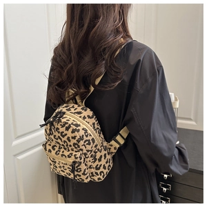 Close-up of small leopard print corduroy backpack with front pocket and adjustable straps
