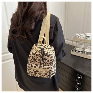 Fashionable leopard print corduroy mini backpack shown on model with adjustable straps