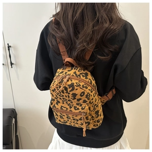 Detailed back view of a mini leopard print corduroy backpack with brown straps