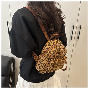 Corduroy leopard print backpack shown from the back on a model for scale and fit