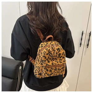 Lifestyle shot of corduroy leopard print backpack on model in minimalist room
