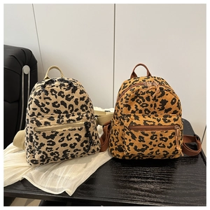 Detailed view of small leopard print corduroy backpacks in light and dark brown tones